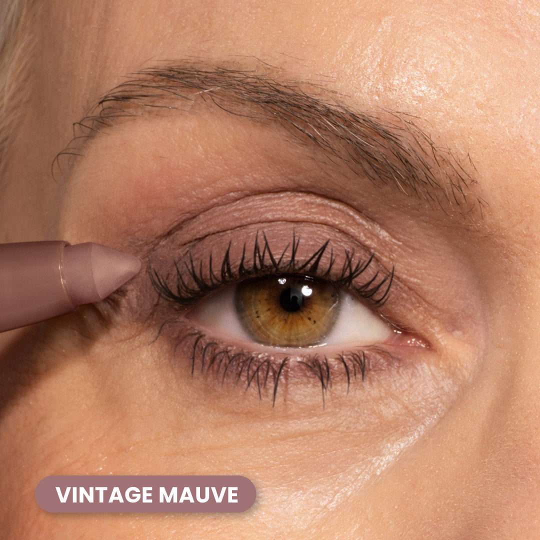 A close-up of a persons eye with mauve-colored eyeshadow and eyeliner. A mauve eye pencil is applied to the upper lash line. The text VINTAGE MAUVE appears at the bottom left.